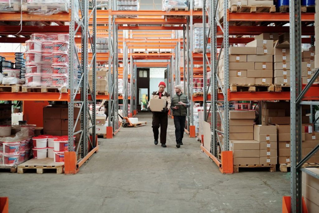 Medewerkers in een magazijn met stellingen