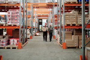 Medewerkers in een magazijn met stellingen